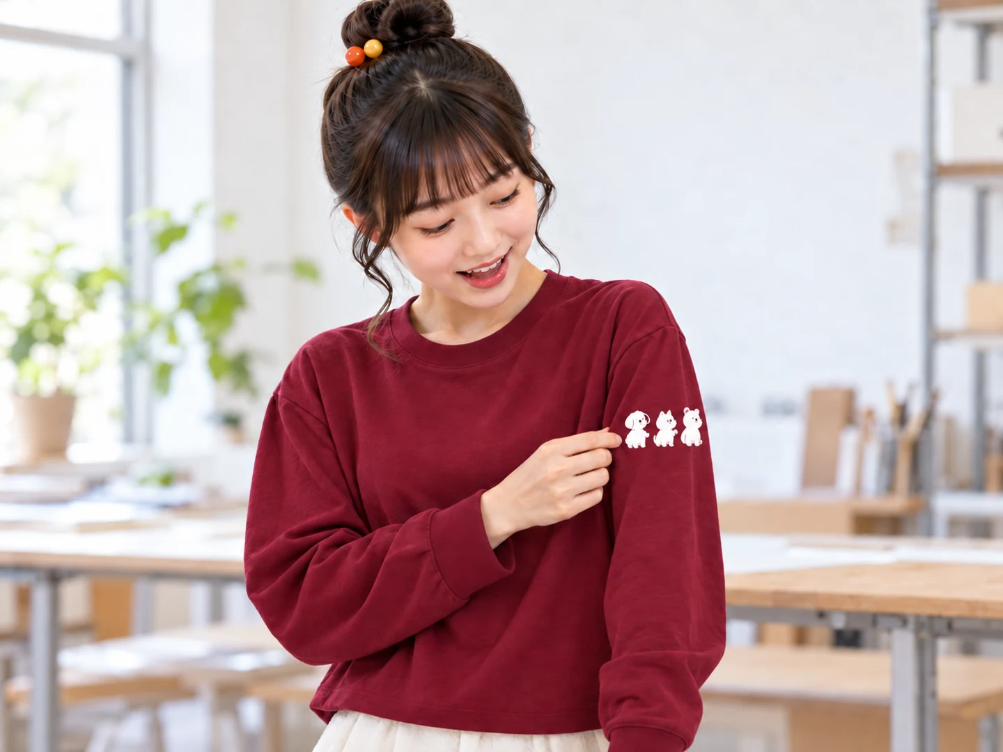 バーガンディの長袖を着た看板娘が、袖の外側に横並びで入れた白い動物プリントを眺める